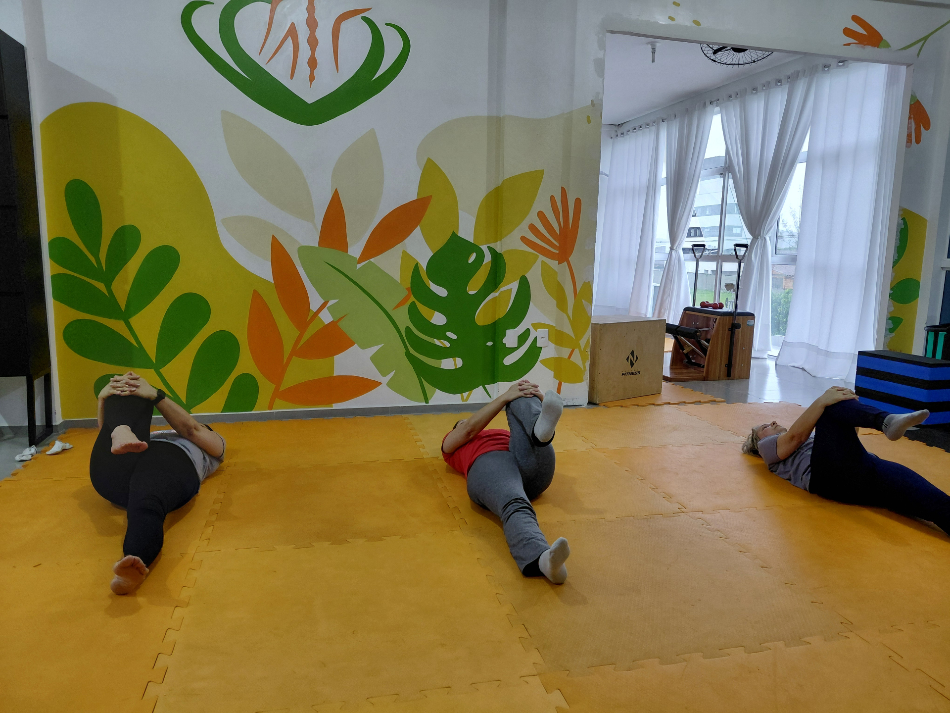 Sala ampla com mural artístico para aulas de mat e funcional